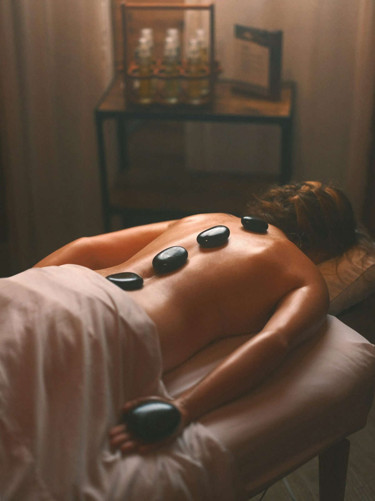 Hot massage stones placed on someone's back